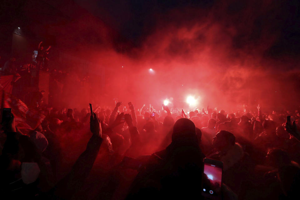 Liverpool fans celebrate outside Anfield stadium after the English Premier soccer match between Liverpool and Chelsea, Wednesday, July 22, 2020, in Liverpool, England. (Martin Rickett/PA via AP)