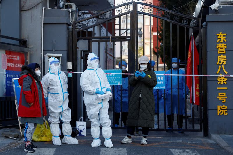 FILE PHOTO: Security personnel stand at the gate of a residential compound that is under lockdown in Beijing