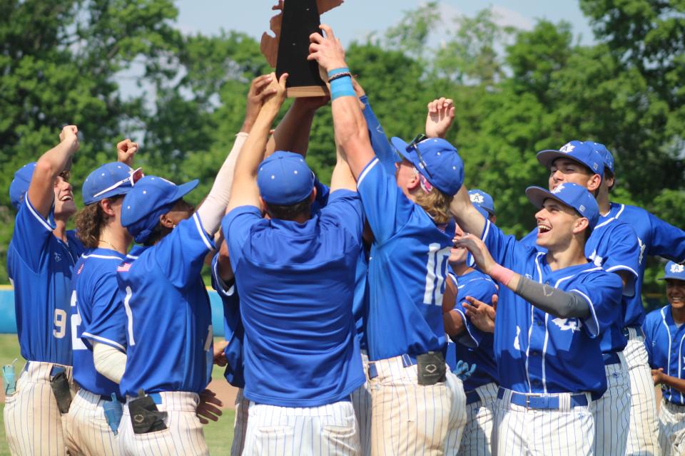 The Adrian baseball team hoists the Division 2 district championship trophy after defeating Milan on Saturday.