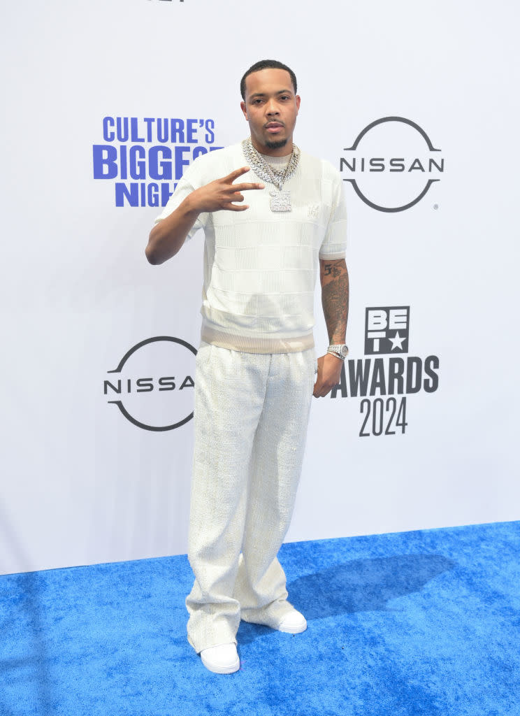 G Herbo on the BET Awards 2024 red carpet, dressed in a casual knit polo shirt and matching pants, posing with hand gesture