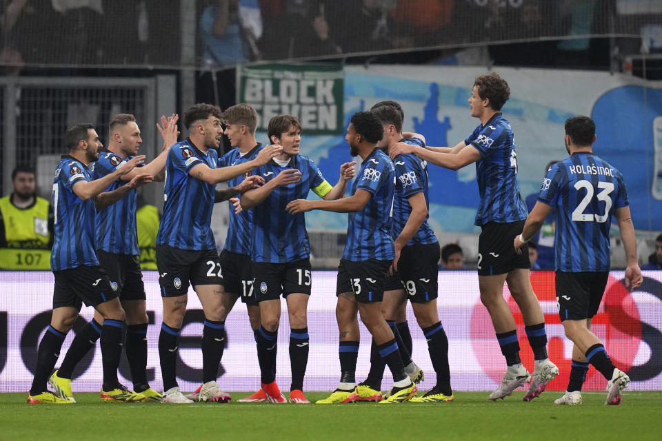 Atalanta's Gianluca Scamacca celebrates with teammates after scoring his sides first goal during the Europa League semifinal first leg soccer match between Olympique de Marseille and Atalanta at the Velodrome stadium in Marseille, France, Thursday, May 2, 2024. (AP Photo/Daniel Cole)