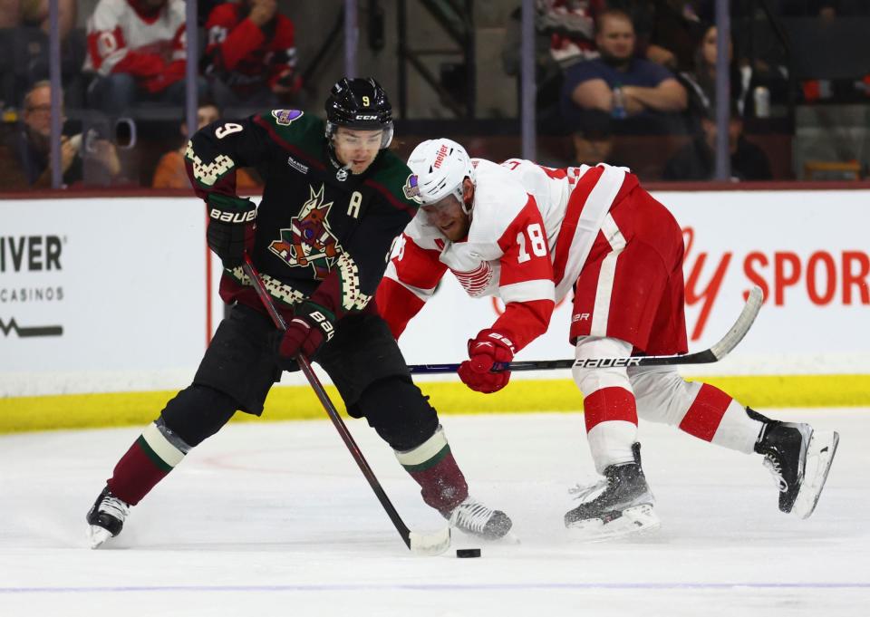 Coyotes right wing Clayton Keller moves the puck against Red Wings center Andrew Copp during the first period on Tuesday, Jan. 17, 2023, in Tempe, Arizona.