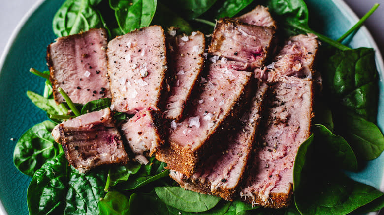 sliced tuna steaks on greens