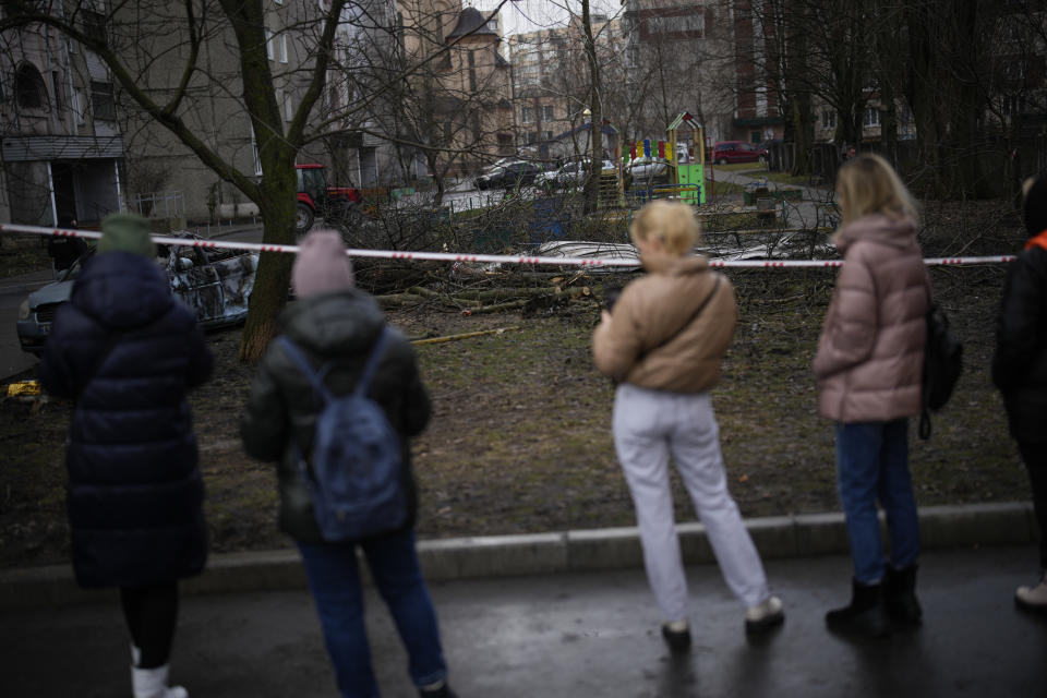 People stand by the scene where a helicopter crashed into civil infrastructure on Wednesday, in Brovary, on the outskirts of Kyiv, Ukraine, Friday, Jan. 20, 2023. (AP Photo/Daniel Cole)