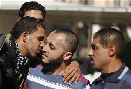 A Palestinian man (C) is hugged by a relative after he was freed from a Hamas-run jail in Gaza City January 8, 2014. REUTERS/Suhaib Salem