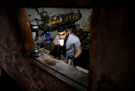 Palestinian cyclist Alaa Al-Daly, 21, who lost his leg by a bullet fired by Israeli troops, drinks milk at the kitchen of his house in Rafah, southern Gaza Strip, April 18, 2018. REUTERS/Suhaib Salem