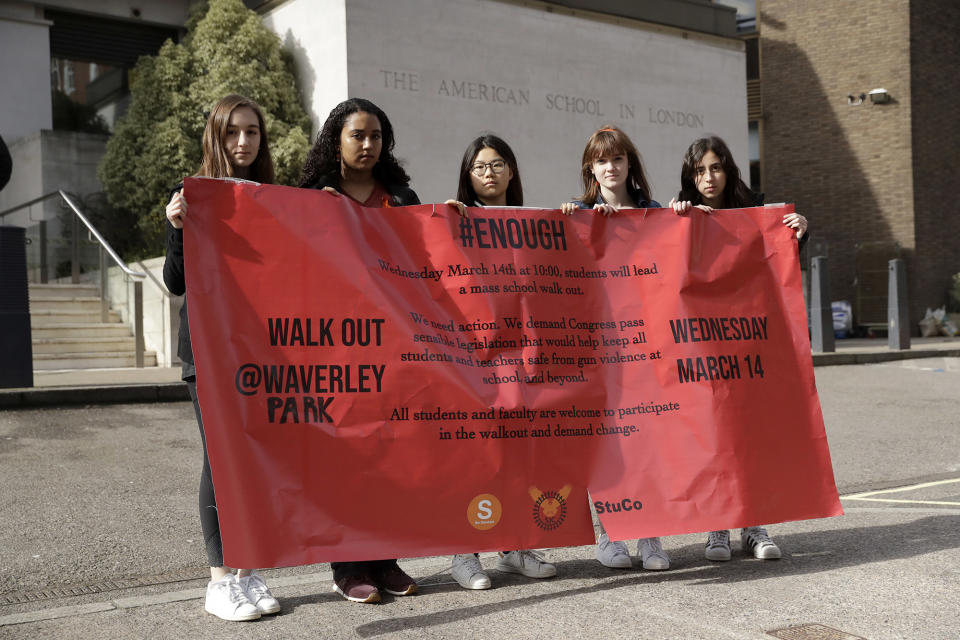 <p>Students, age 17 and 18, pose for photographs with a banner outside the American School in London, after taking part in a 10 a.m. local time, 17-minute walkout in the school playground, which was attended by approximately 300 students aged 14-18. (Photo: Matt Dunham/AP) </p>