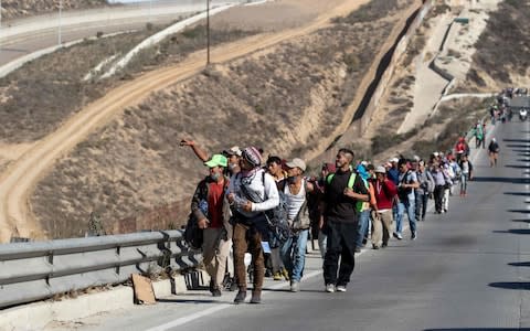 The first group from the caravan from poor Central American countries -mostly Hondurans- are seen near the US border in Playas de Tijuana, Mexico - Credit: AFP