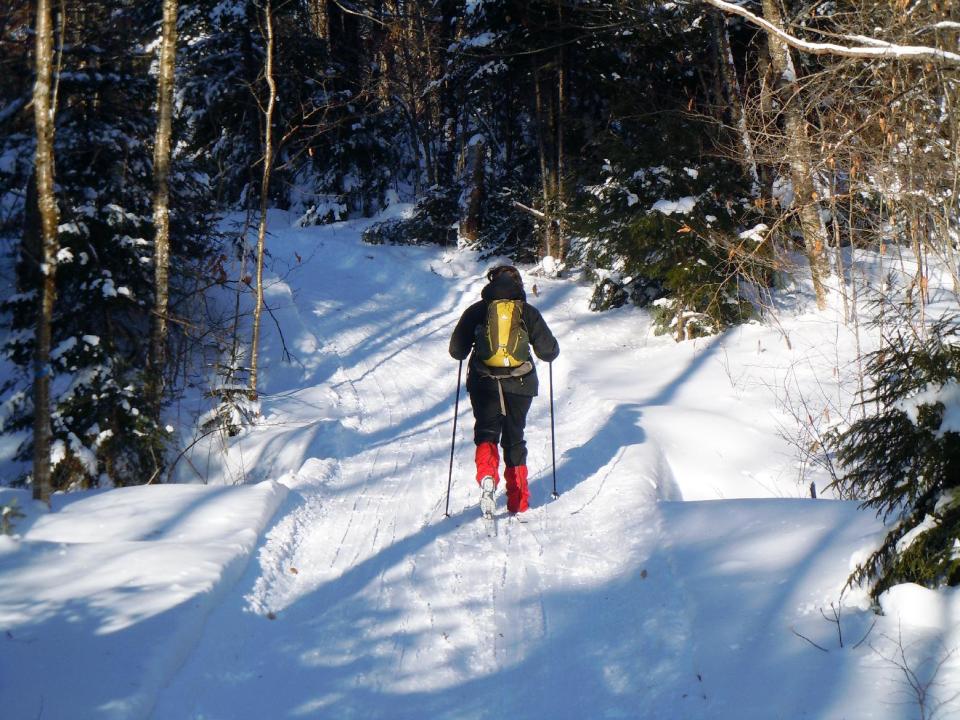 This December 2012 photo shows Donna Lawlor cross-country skiing on the Lodge to Lodge trail between camps at the Appalachian Mountain Club’s backcountry wilderness lodge near Greenville, Maine. In winter, visitors can reach the lodges and cabins only by cross-country skiing in. (AP Photo/Lynn Dombek)