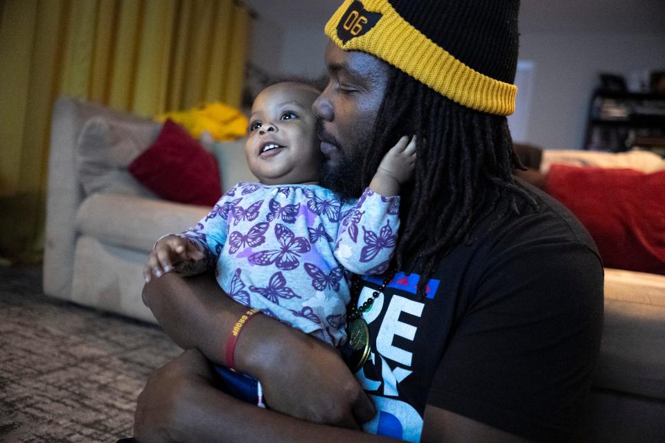 Ernest Levert Jr. kisses his 16-month-old daughter Zamya on the cheek while watching a children’s show in their home on Friday night. “We just want to give her as many tools and opportunities to learn about herself and her gifts, and to discover who she wants to be,” Levert Jr. said.