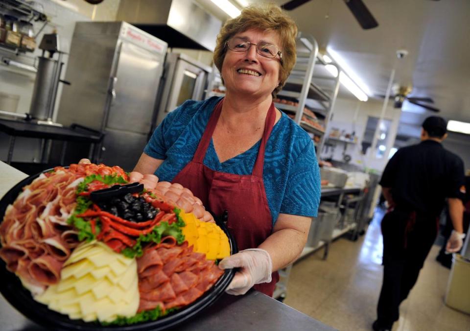 Angela Marziliano, who opened the business with her husband Sam, shows a platter prepared for pick-up at Sam’s Italian Deli and Market Thursday in this file photo from 2014.