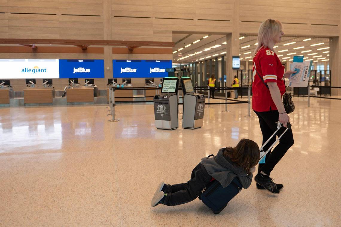 Rachelle Landreth, right, and her four-year-old son Ozzy Nacis, finish a flying simulation tour at the new single terminal at Kansas City International Airport on Tuesday, Feb. 14, 2023.