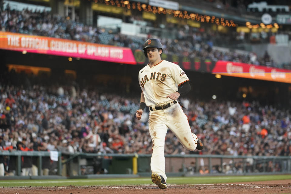 San Francisco Giants' Mike Yastrzemski scores on a passed ball by Milwaukee Brewers catcher Victor Caratini during the third inning of a baseball game in San Francisco, Thursday, July 14, 2022. (AP Photo/Godofredo A. Vásquez)