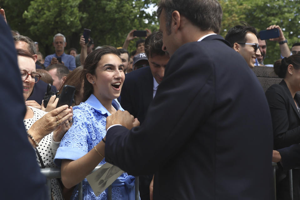 CORRECTS BYLINE - A woman gives to French President Emmanuel Macron of portrait of him after the annual Bastille Day military parade, in Paris, Friday, July 14, 2023. India is the guest of honor at this year's Bastille Day parade, with Prime Minister Narendra Modi in the presidential tribune alongside French President Emmanuel Macron. (AP Photo/Aurelien Morissard)