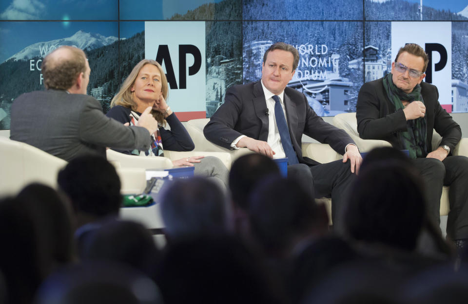 AP Senior Managing Editor Michael Oreskes, left, moderates a discussion with, from left, Save the Children International CEO Jasmine Whitbread, British Prime Minister David Cameron and rock star Bono during a panel discussion "The Post-2015 Goals: Inspiring a New Generation to Act", the fifth annual Associated Press debate, at the World Economic Forum in Davos, Switzerland, Friday, Jan. 24, 2014. (AP Photo/Michel Euler)