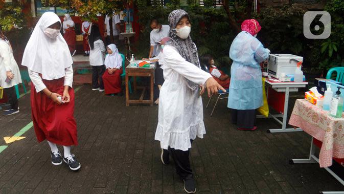 Petugas kesehatan mengarahkan siswa saat tes usap PCR di SDN Sudimara Barat 5, Kota Tangerang, Rabu (12/1/2022). Tes usap dilakukan untuk mengantisipasi penyebaran COVID-19 di sekolah setelah dimulainya pembelajaran tatap muka kapasitas kelas 100 persen di Kota Tangerang. (Liputan6.com/Angga Yuniar)