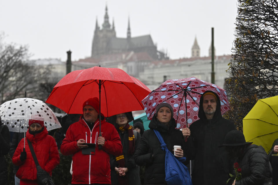 Mourners observe a minute of silence for the victims of mass shooting in front of the building of Philosophical Faculty of Charles University in downtown Prague, Czech Republic, Saturday, Dec. 23, 2023. A lone gunman opened fire at a university on Thursday, killing more than a dozen people and injuring scores of people. (AP Photo/Denes Erdos)