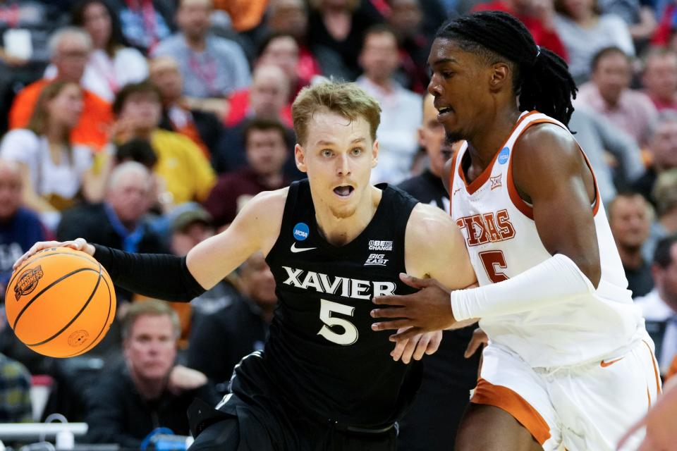 Xavier Musketeers guard Adam Kunkel (5) drives as Texas Longhorns guard Marcus Carr (5) defends during the first half of a Sweet 16 college basketball game between the Xavier Musketeers and the Texas Longhorns in the Midwest Regional of the NCAA Tournament, Friday, March 24, 2023, at T-Mobile Center in Kansas City, Mo.