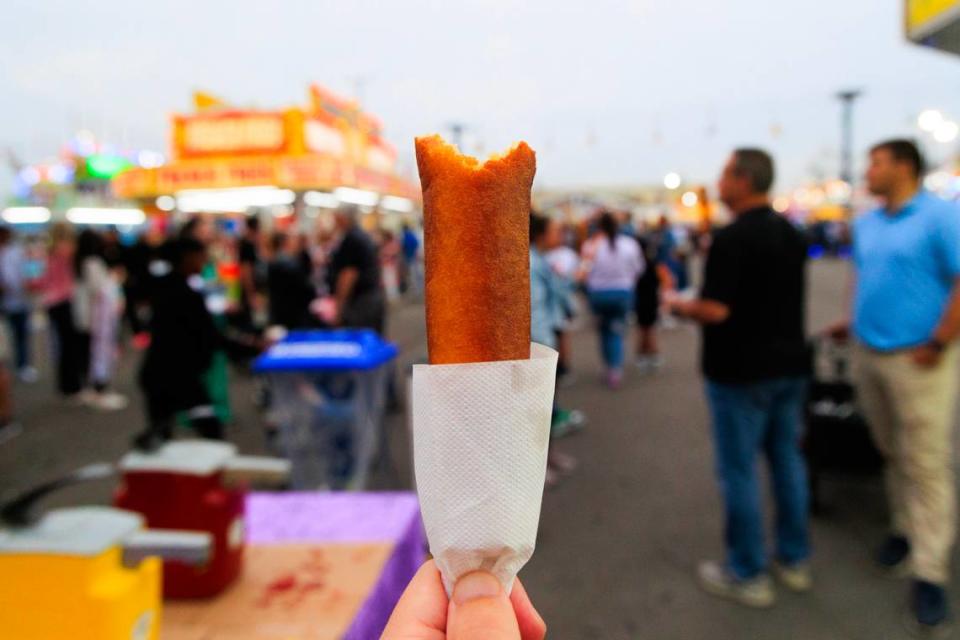 The State photojournalist Joshua Boucher shows a Pronto Pup during the opening day of the South Carolina State Fair on Wednesday, October 11, 2023. Pronto Pups are made with pancake batter instead of a cornmeal batter that more common corndogs use.