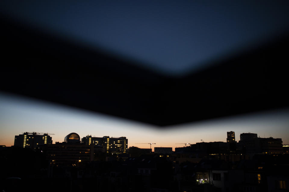 The European Parliament building, left, is silhouetted against the sky as the sun sets during a partial lockdown against the spread of the coronavirus or COVID-19 in Brussels, Monday, April 20, 2020. (AP Photo/Francisco Seco)