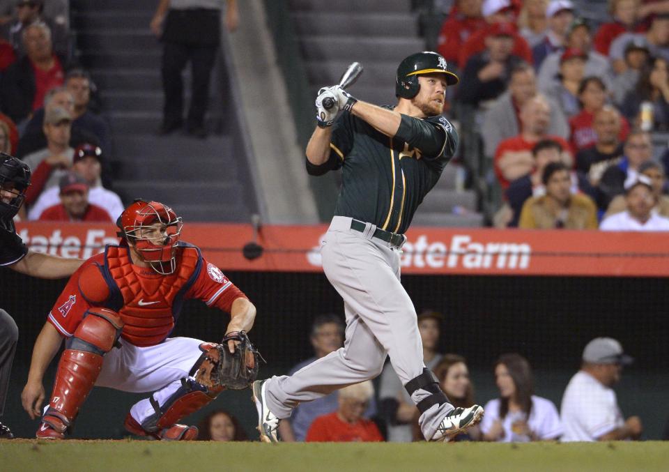 Oakland Athletics' Brandon Moss watches his three-run home run in front of Los Angeles Angels catcher Chris Iannetta during the fourth inning of a baseball game, Wednesday, April 16, 2014, in Anaheim, Calif. (AP Photo/Mark J. Terrill)