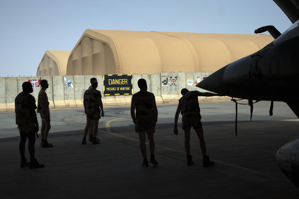 FILE - French Barkhane Air Force mechanics maintain a Mirage 2000 on the Niamey, Niger base on June 5, 2021. President Emmanuel Macron says France will end its military presence in Niger and pull its ambassador out of the country after its democratically elected president was deposed in a coup. France has maintained some 1,500 troops in Niger since the July coup and refused an order by the new junta for its ambassador to leave. (AP Photo/Jerome Delay, File)