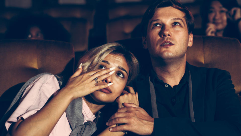 woman crying and leaning into her date at the movies