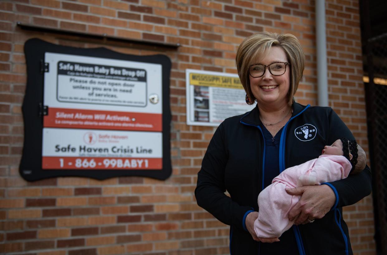 Melissa Sullivan, Crisis Pregnancy Center executive director, holds the demonstration baby in front of the Safe Haven Baby Box at Simpson General Hospital in Mendenhall, Miss., on Tuesday, Feb. 20, 2024.