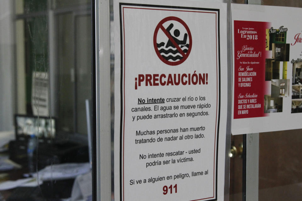 This June 13, 2019, photo shows a sign that reads "Many people have died trying to swim to the other side," posted in a church sheltering Central American migrants in Ciudad Juarez, Mexico. The irrigation canals near El Paso look calm on the surface and easy to cross, but their V-shape creates a quick undertow. (AP Photo/Cedar Attanasio)