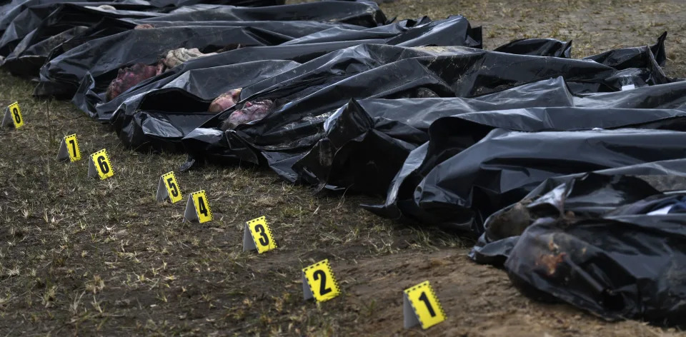 Numbers identify more than eight bodies pulled from a mass grave behind a church in Bucha.