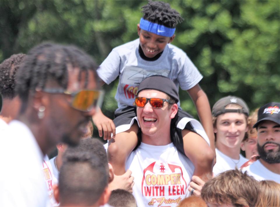 NFL tight end and Chatham Glenwood graduate Daniel Helm hoists a kid during the Leek & Friends Football Camp at Sacred Heart-Griffin on Saturday, July 9, 2022.