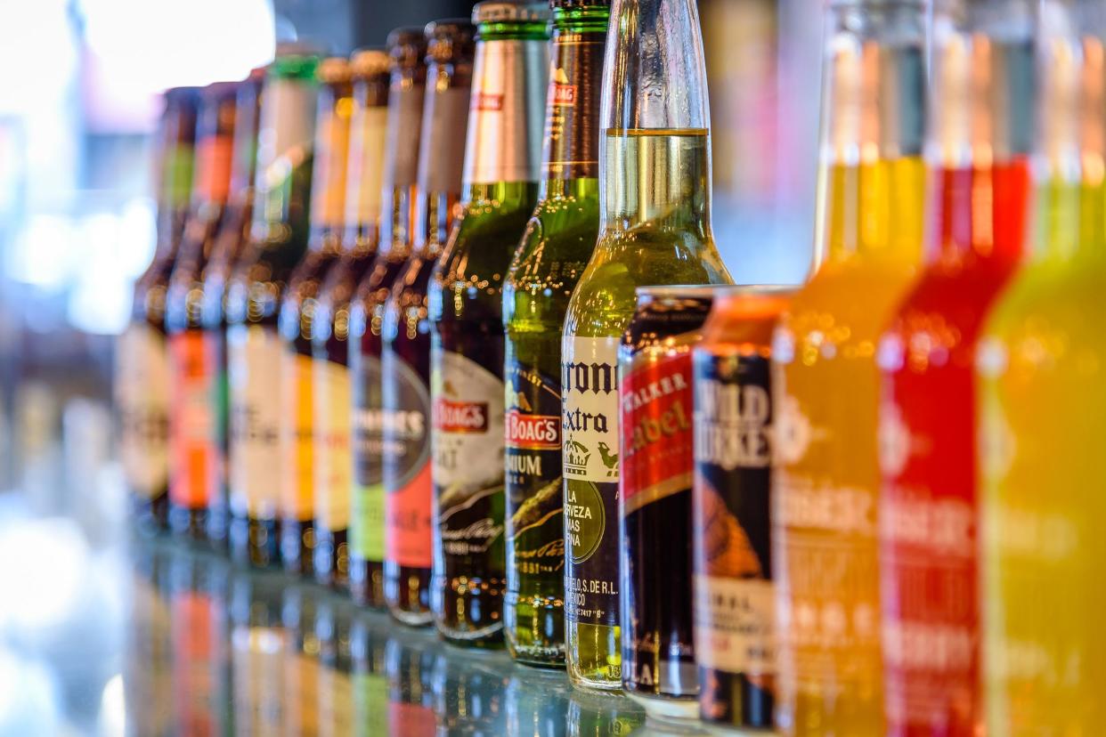 row of bottles and cans of alcoholic drinks on display