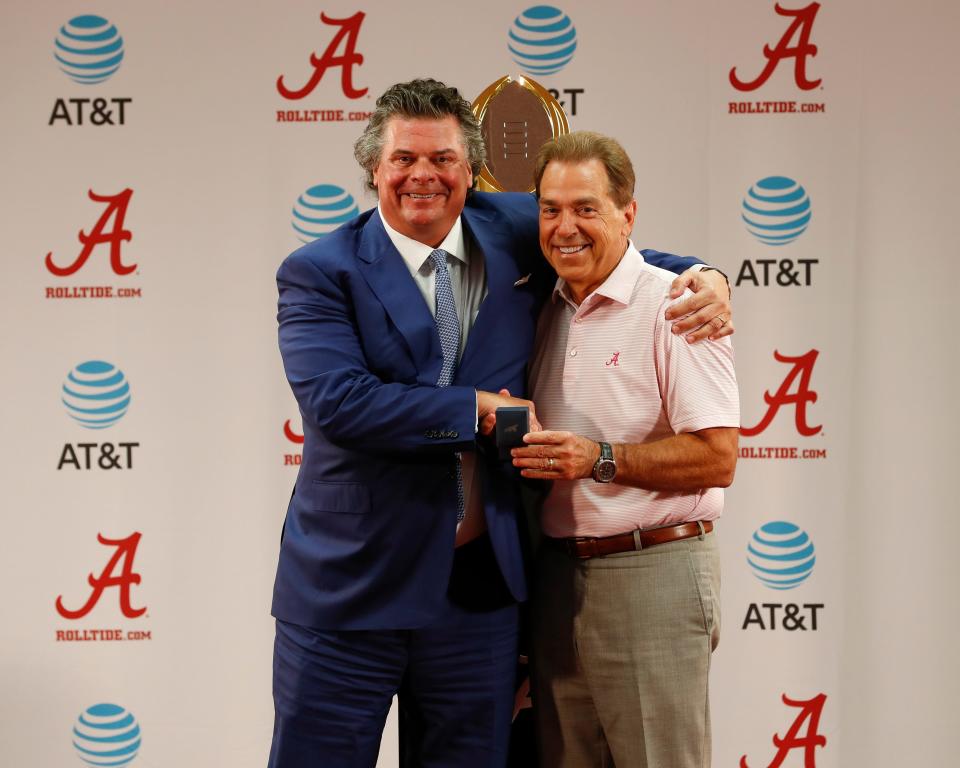 Nick Saban gives a national championship ring to trustee Jim Wilson on June 8, 2018.