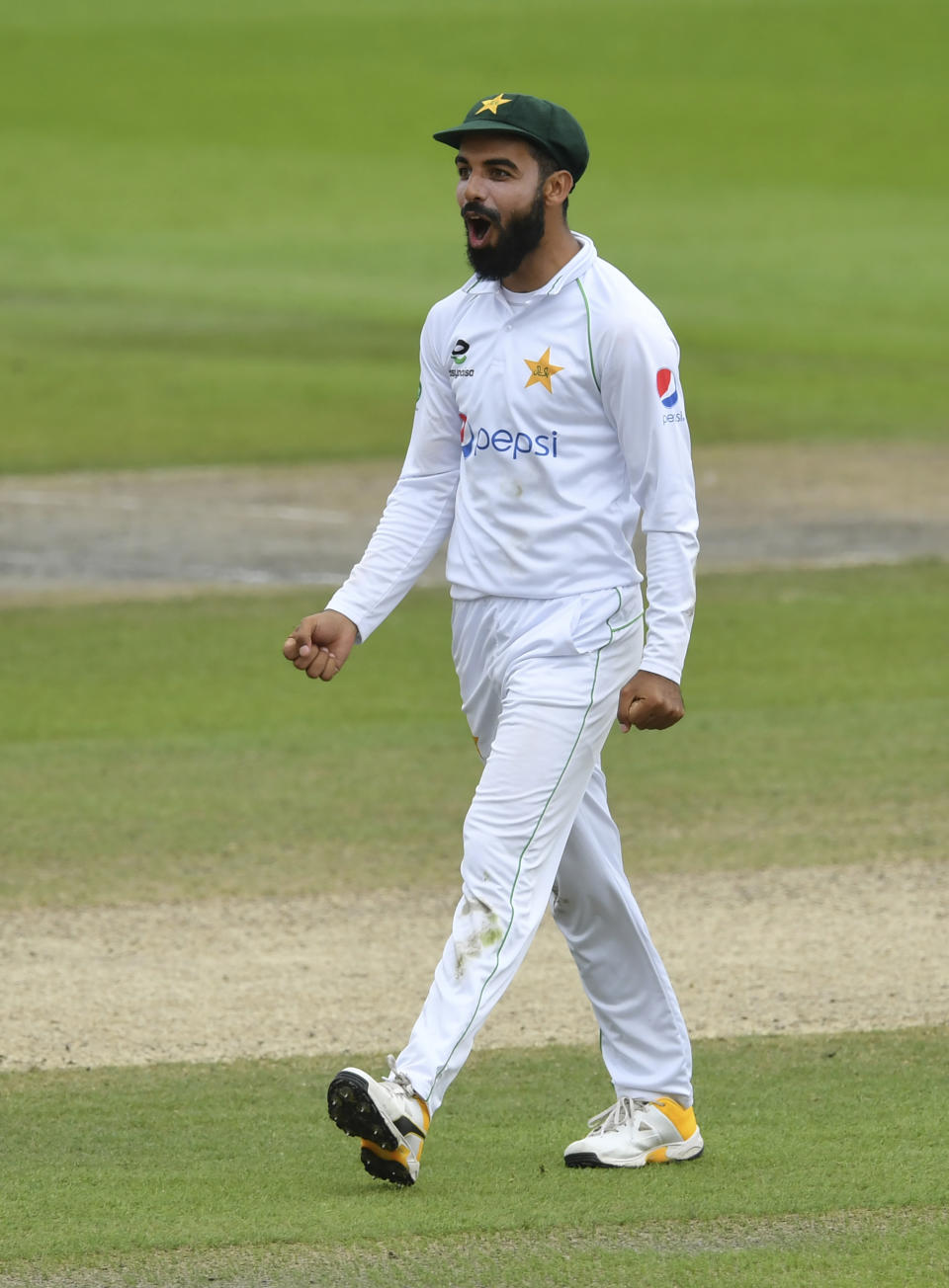 Pakistan's Shadab Khan celebrates the dismissal of England's Ollie Pope during the fourth day of the first cricket Test match between England and Pakistan at Old Trafford in Manchester, England, Saturday, Aug. 8, 2020. (Dan Mullan/Pool via AP)