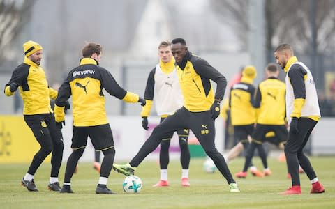 Usain Bolt tries to get the ball off Mario Gotze - Credit: Getty images