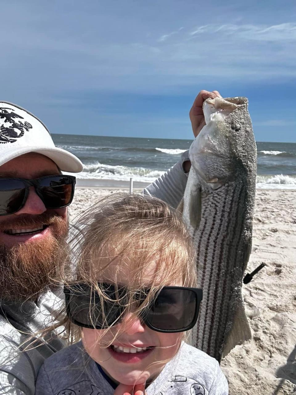 Ken Konopka and his daughter Laine of Tabernacle with a striped bass caught this weekend in the County surf.