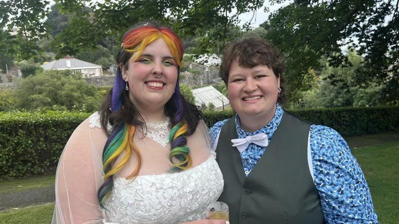 The couple in their wedding outfits, a wedding dress and a suit and waistcoat 