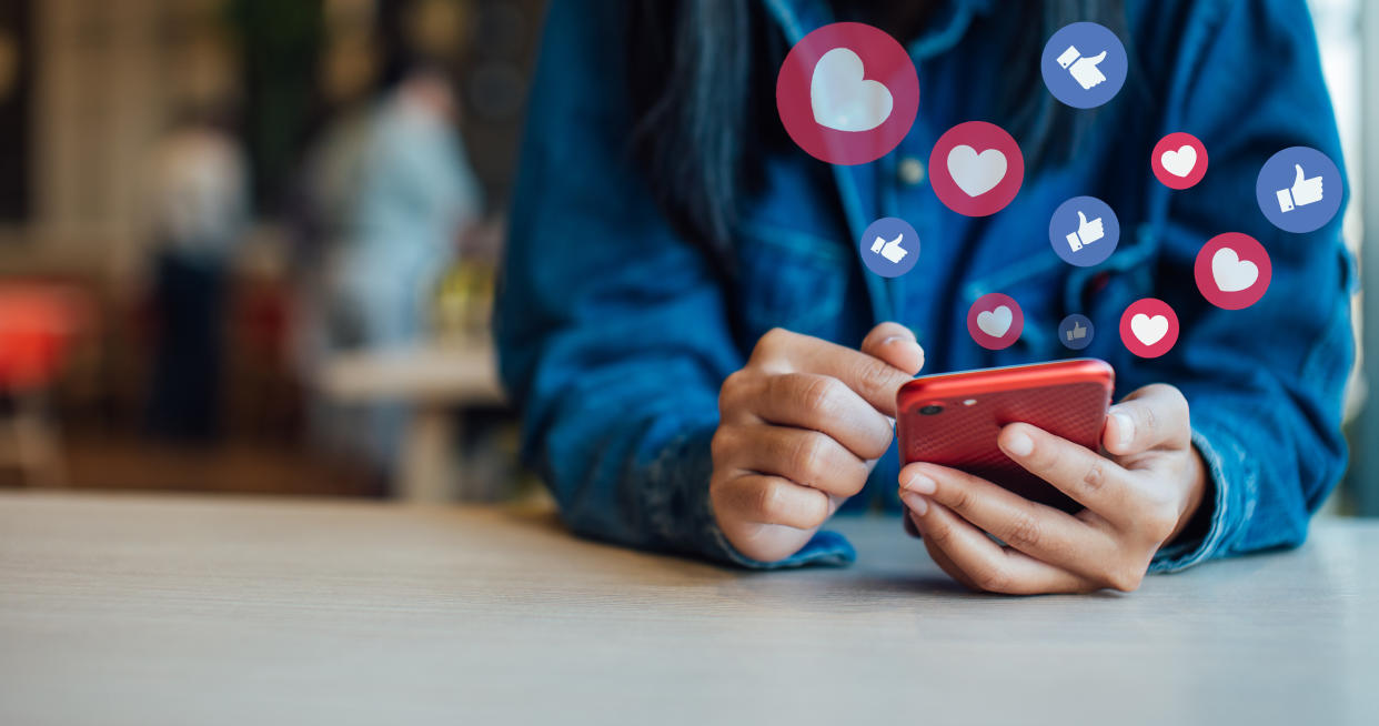 Midsection Of Woman Using Smart Phone On Table In Cafe