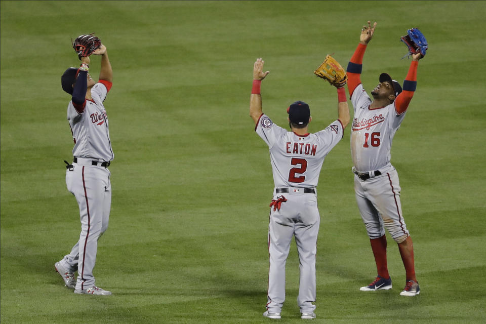 Washington Nationals' Juan Soto, left, celebrates with teammates Adam Eaton, center, and Victor Robles, right, after a baseball game against the New York Mets Tuesday, Aug. 11, 2020, in New York. The Nationals won 2-1. (AP Photo/Frank Franklin II)