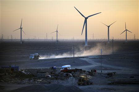 A construction site is seen near wind turbines for generating electricity, at a wind farm in Guazhou, 950km (590 miles) northwest of Lanzhou, Gansu Province September 15, 2013. REUTERS/Carlos Barria