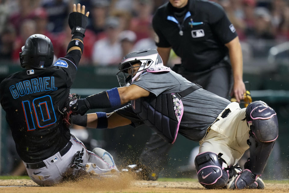 Washington Nationals catcher Keibert Ruiz, right, loses the ball as Miami Marlins' Yuli Gurriel scores during the eighth inning of a baseball game at Nationals Park, Friday, June 16, 2023, in Washington. The Marlins won 6-5. (AP Photo/Alex Brandon)