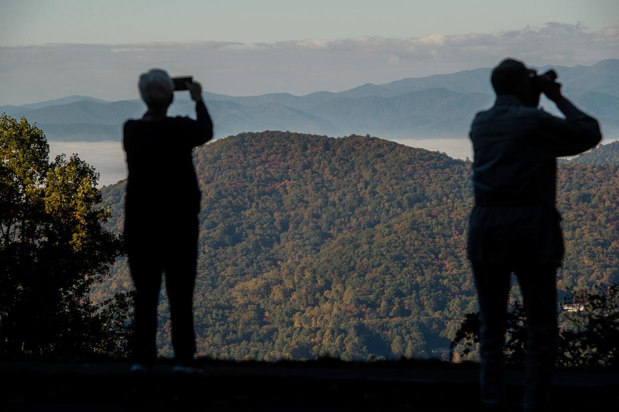 People take pictures at the Bull Creek Valley viewpoint on the Blue Ridge Parkway, October 19, 2023.