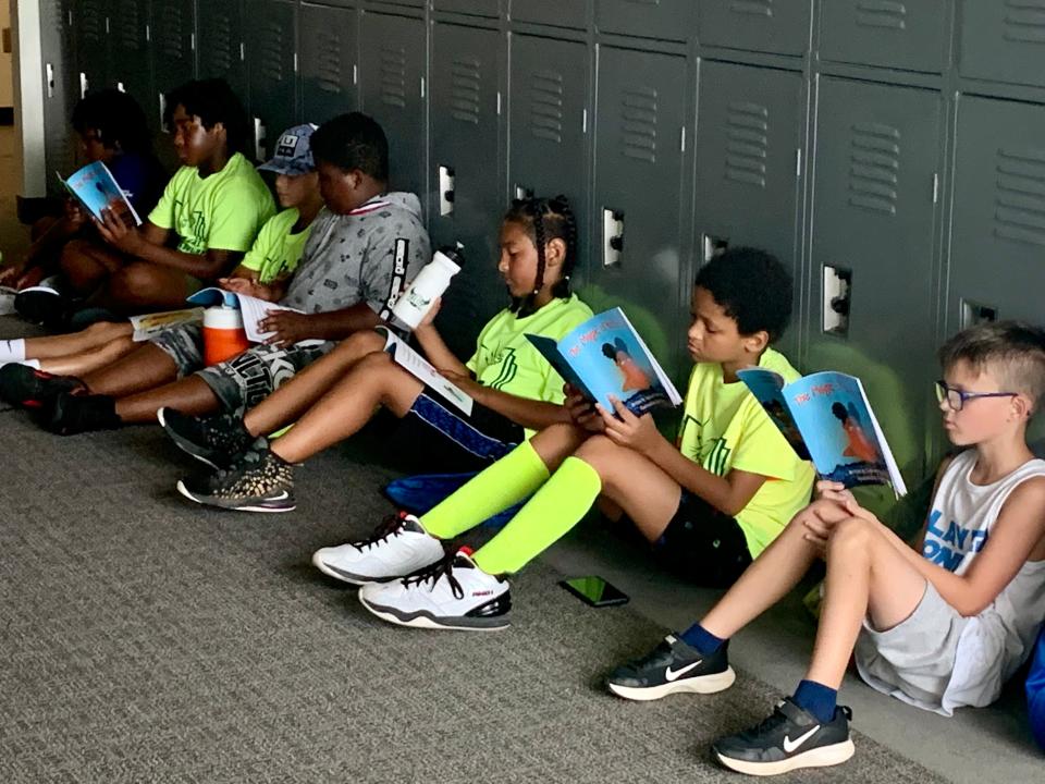 Students read a book together during their school's summer learning program.