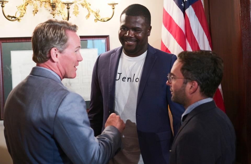 Former Ohio State Buckeyes quarterback Cardale Jones, center, chats with Ohio Lt. Gov. Jon Husted, left, and Brian Schottenstein, right, president of the Schottenstein Real Estate Group, after Ohio Gov. Mike DeWine, not pictured, signed an executive order permitting college student-athletes to profit off their name, image and likeness during a ceremonial signing on Monday, June 28, 2021 at the Ohio Statehouse in Columbus, Ohio.