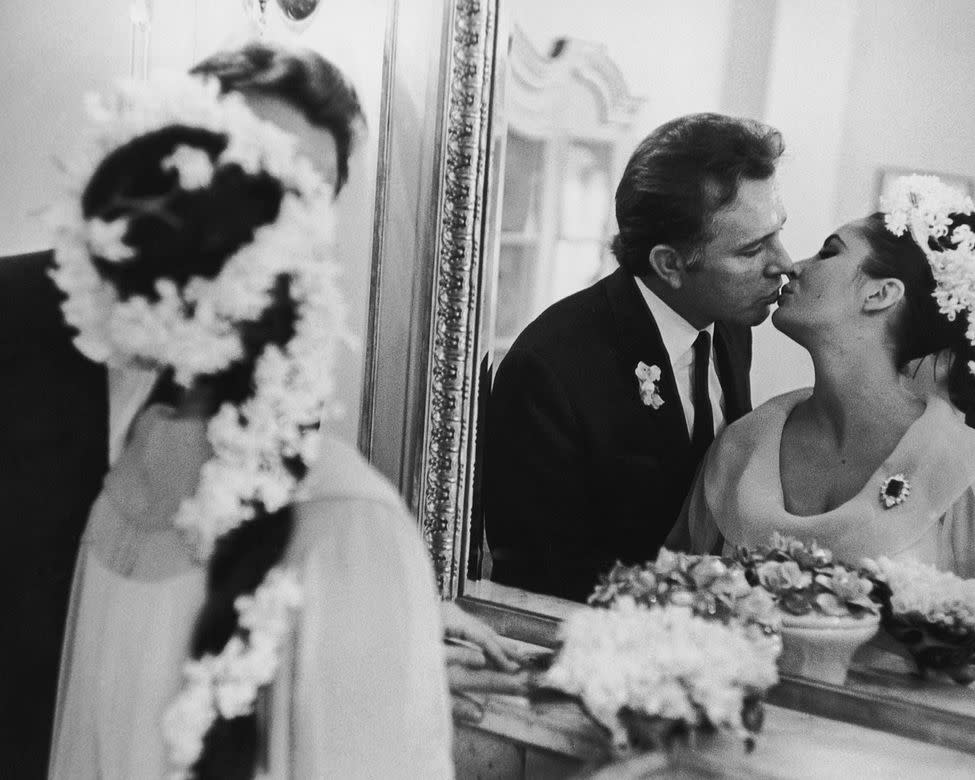 elizabeth taylor and richard burton kiss in wedding outfits in front of mirror