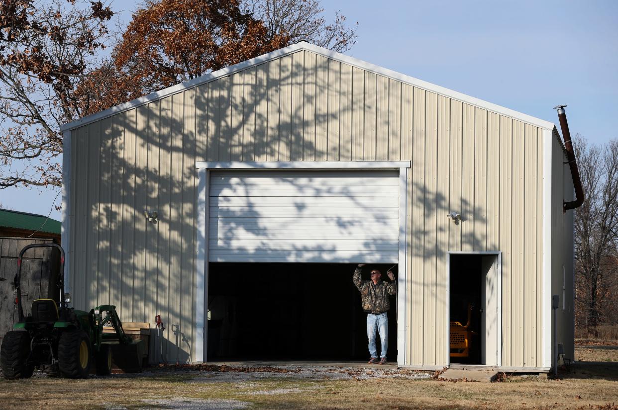 Eddie Peacher closed the garage door to a building on his property near Jay, Okla., on Dec. 3, 2022. The property was formerly owned by Andrew Scott Pierson's mother, Betty Cook, and Pierson was accused of using the building to alter Colt M4A1 rifles with counterfeit parts to supply Mexican cartels.