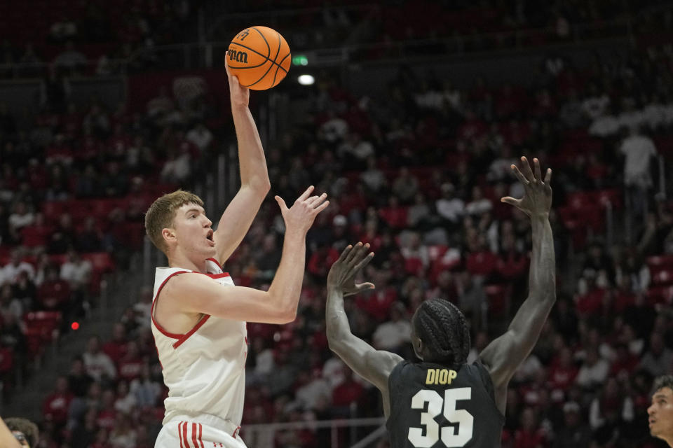 Utah center Lawson Lovering, left, shoots as Colorado forward Assane Diop (35) defends during the second half of an NCAA college basketball game Saturday, Feb. 3, 2024, in Salt Lake City. (AP Photo/Rick Bowmer)