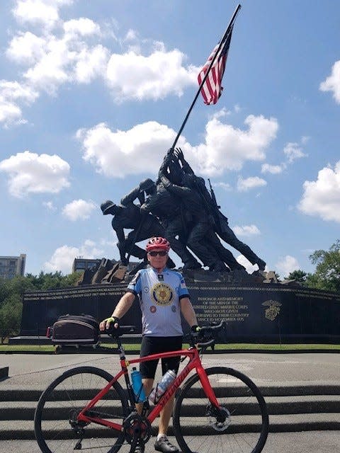 On day 74 of his cross-country bicycle ride in 2019, Story County native Larry Ritland takes a break in front of the Iwo Jima memorial in Washington, DC.