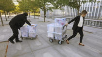 Officials wheel evidence in to the federal courthouse Monday, Aug. 12, 2019, in Salt Lake City. Former Eagle Scout Aaron Shamo, 29, will stand trial on allegations that he and a small group of fellow millennials ran a multimillion-dollar empire from the basement of his suburban Salt Lake City home by trafficking hundreds of thousands of pills containing fentanyl, the potent synthetic opioid that has exacerbated the country's overdose epidemic in recent years. (AP Photo/Rick Bowmer)