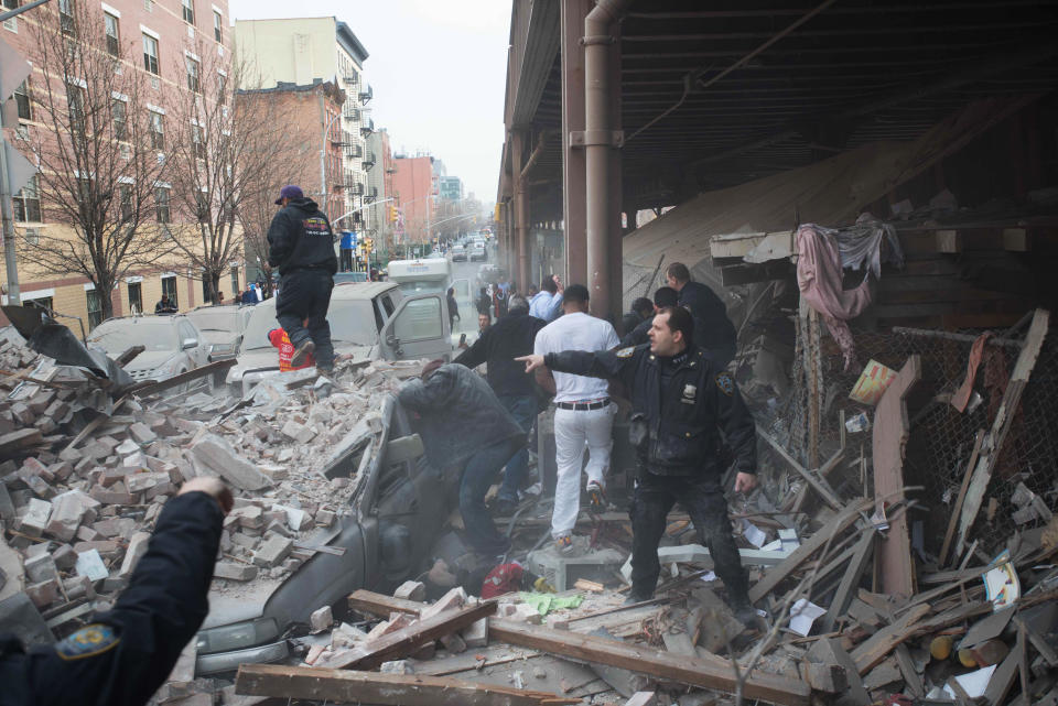 Policías asisten en labores de socorro en el lugar de una explosión que derrumbó dos edificios y provocó la muerte de dos personas en East Harlem, en Nueva York, el miércoles 12 de marzo de 2014. (AP Foto/Jeremy Sailing)